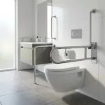 Barra de apoio articulada inox com porta-papel 60cm instalada ao lado do vaso em banheiro acessível